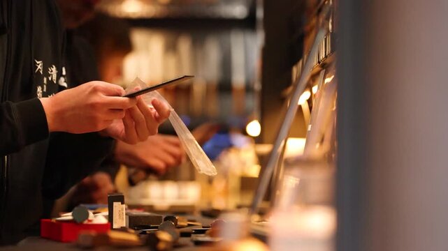 Japanese Artisan Inspecting Handcrafted Steel Knife in Tokyo Workshop