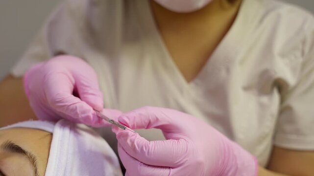Professional dermatologist preparing a scalpel for dermaplaning