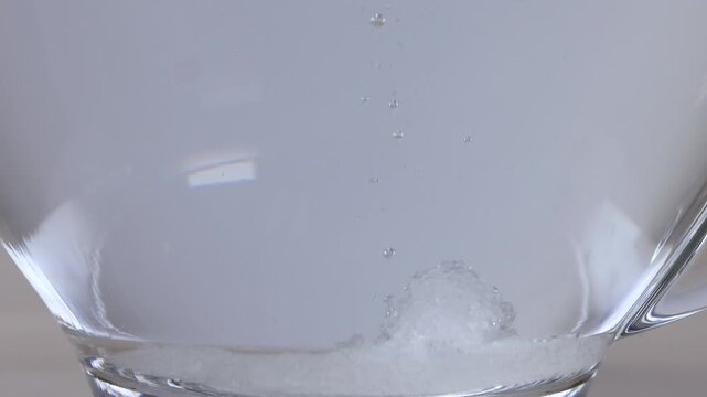 Sugar Crystals Dissolving in a Glass Mug of Hot Water