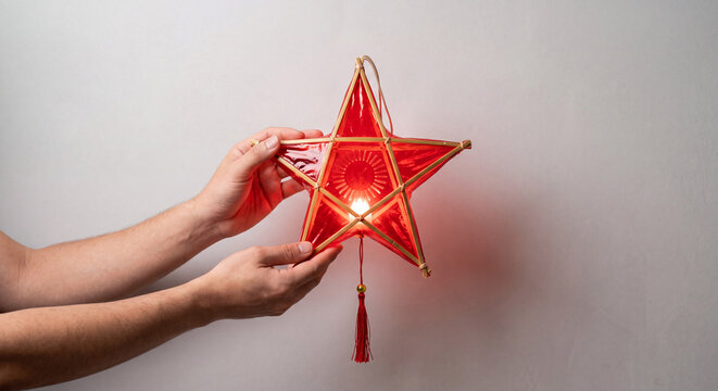 Hands holding traditional red star lantern with candle light for Mid Autumn Festival