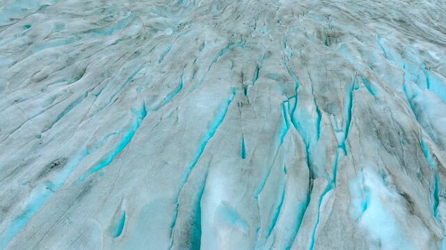 Aerial drone footage of the Nigardsbreen glacier, one of the glacier arms of the Jostedalsbreen ice cap in Norway. Various views show the blue-white glacier ice, crevasses, rocky surroundings and melt