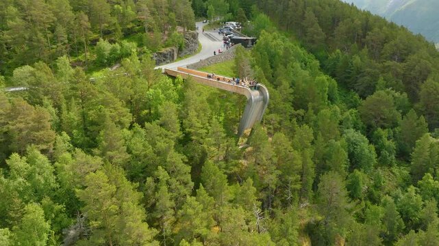 Aerial drone footage of Stegastein viewpoint in Aurland, Norway, surrounded by steep forested mountains and the scenic Aurlandsfjord landscape.
