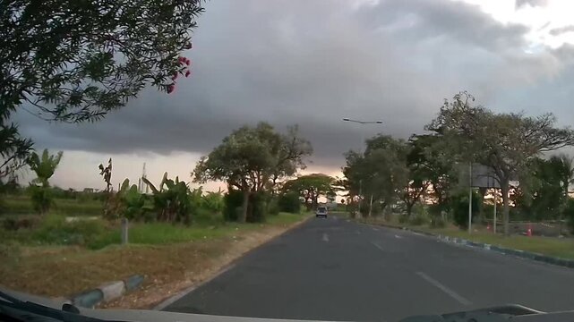 Front Dashcam Driving on Indonesian Road Under Dramatic Heavy Clouds on a Quiet Morning
