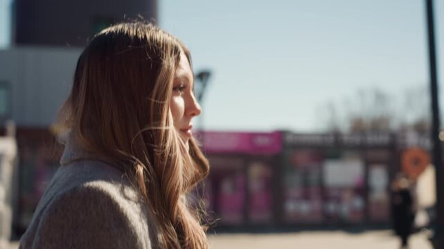 Reflective woman gazes upward. Contemplative woman with tousled hair looks towards distant city skyline. Pensive female figure with windblown hair gazes at expansive urban horizon thoughtfully