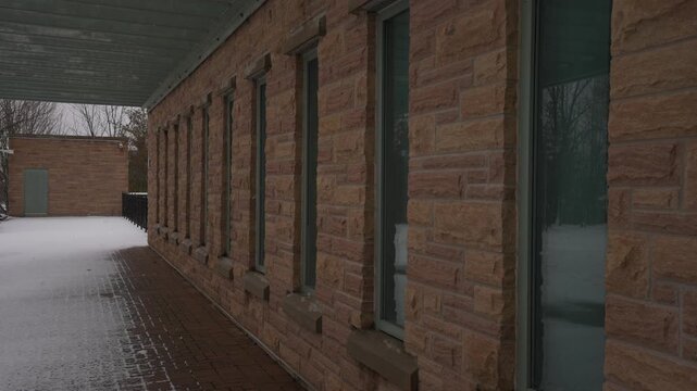 Exterior wall, concrete industrial facade with repeating glass windows at Ajax Water Supply Plant, Ontario, Canada, winter, daytime, medium shot, slow panning movement.