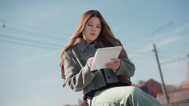 Elegant sketching scene. Stylish individual drafting plans amidst bustling city environment. Focused architect sketching detailed layout outside surrounded by modern urban scenery and notes