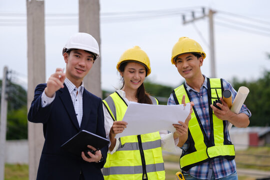 Architects, engineers and a manager discussing blueprints during a site inspection.