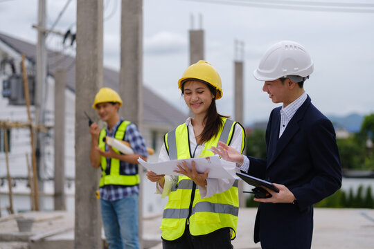 Architects, engineers and a manager discussing blueprints during a site inspection.