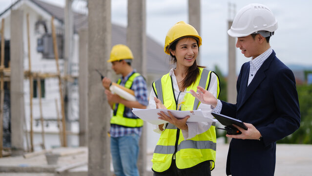 Architects, engineers and a manager discussing blueprints during a site inspection.