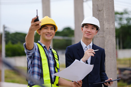 Construction professionals using a two-way radio during a building site inspection.