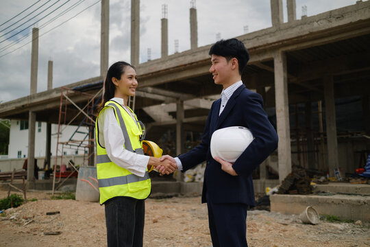 Construction professionals shaking hands after reaching a project agreement on site.