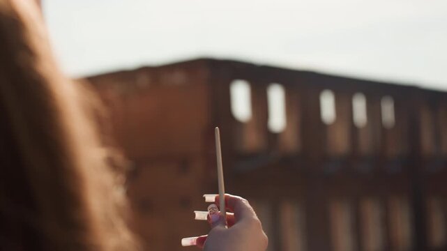 Youthful gesture against brick backdrop. Playful arm reaching for sunlit cityscape scene. Vivid urban snapshot capturing joyful gesture illuminated by golden sunlight and celebratory shimmer
