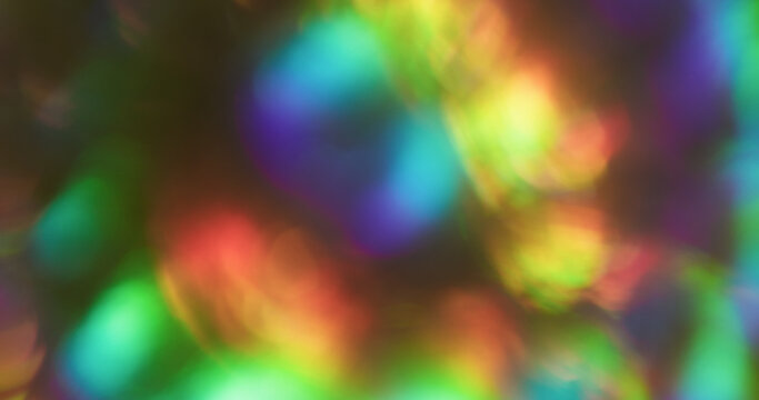 Bokeh glitter flare. Blur light. Pink green blue color radiant illuminated rainbow flash on abstract optical art black luminous background.