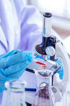 Vertical Horizon Woman scientist lab looks at science microscope medical test research biology chemistry. Scientist Chemistry Medical test lab. Vertical Females Technician Laboratory pharmacy research