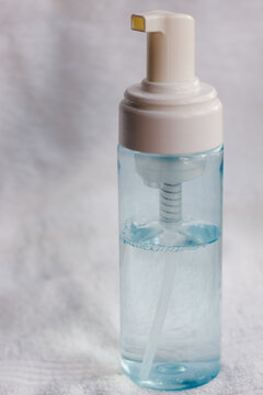 Skincare foaming cleanser bottle with pump dispenser on a white towel, showcasing beauty product packaging for spa, wellness, and personal hygiene concepts