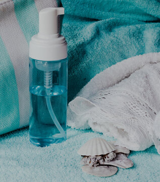 Spa cleanser pump bottle on soft blue towel, creating a sense of wellness and relaxation, with decorative seashells bringing natural beauty and serenity