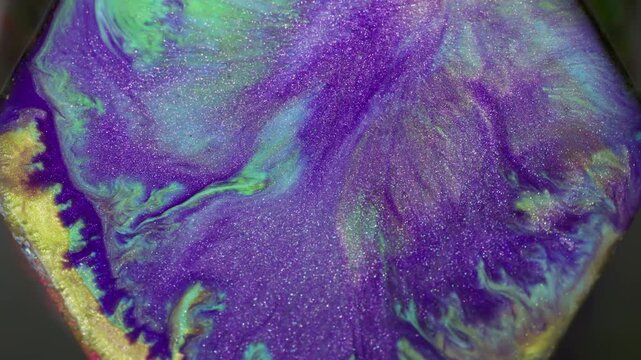 Shiny paint. Glitter ink rhombus. Defocused purple yellow blue colorful fluid stone geometric particles on abstract art background.