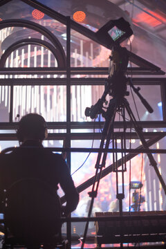 Cameraman with professional TV camera filming live concert on stage with copy space