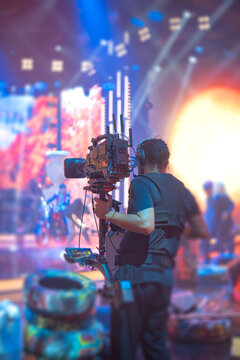 Steadicam operator filming live performance on stage with camera stabilizer and copy space
