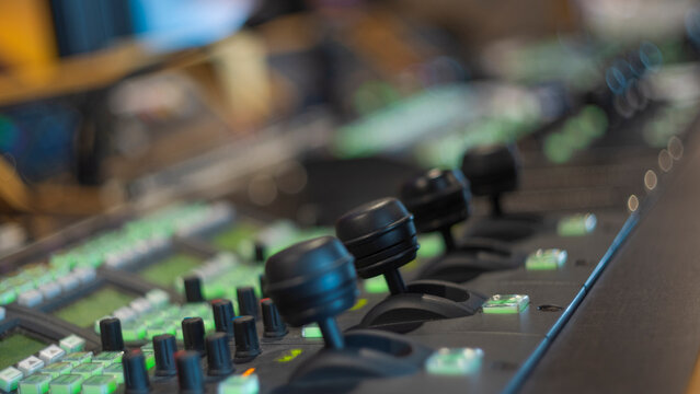 Broadcast switcher control panel with illuminated green buttons and joysticks with copy space