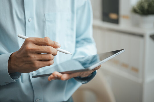 Business professional uses a tablet and stylus to analyze data, review reports, and manage digital workflows.