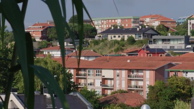 Hillside view of residential houses and apartment buildings with red tile roofs in Sopelana Algorta, Basque Country
