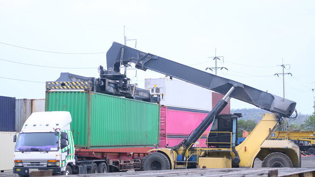 Green container lifted by heavy crane at port