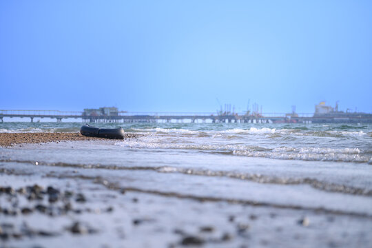 A black lifebuoy, a bridge, and distant industrial factories stretching to the horizon.