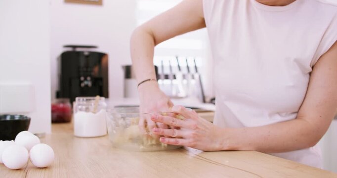 Pastry preparation. Baking cookies. Chef female hand kneading shortbread dough at bowl cooking sweet treat recipe at home kitchen.