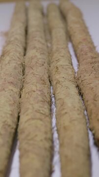 Vertical Video: Dirt on the Chinese yam surface is blown away.