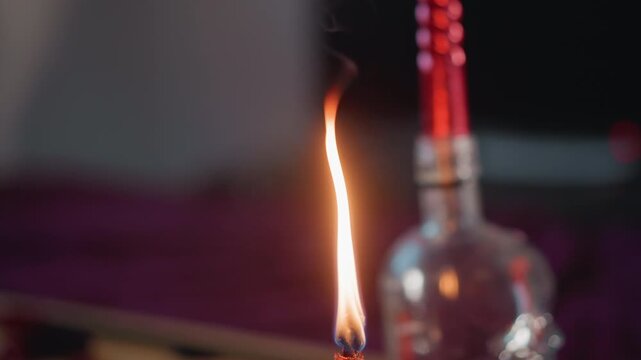 Closeup candle flame near glass bottle, red beads on velvet, slow flicker with thin smoke, ember curling from wick, moody cinematic atmosphere for fortune reading and scrying ritual