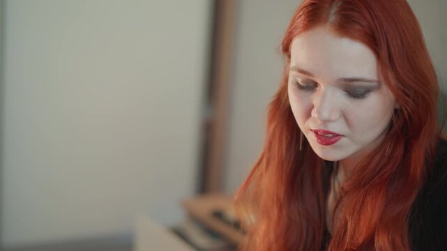 Bright closeup redhead holding cards at desk, warm natural light, gentle smile and playful shuffle, modern reader revealing fortune with delighted expression and upbeat foresight vibe.