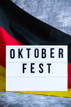 Lightbox with text OKTOBERFEST National symbol of Germany. German wave silky flag background. Concept of traditional beer Bavarian festival. Travel to germany, visit munich european tourism German