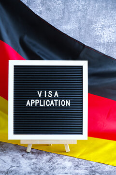 Letter board text VISA APPLICATION National symbol of Germany. German wave silky flag background. Concept of temporary work permit employment migration
