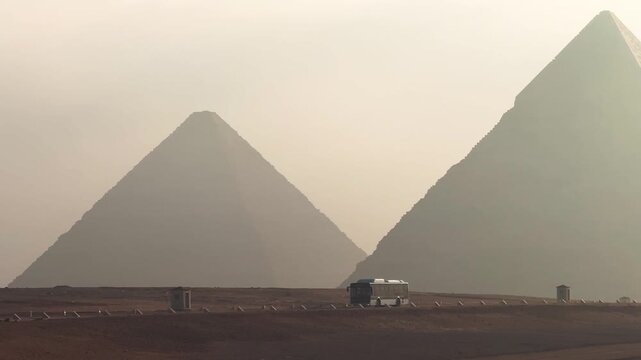Tourist shuttle bus driving inside the Giza Pyramid Complex with pyramids in the background