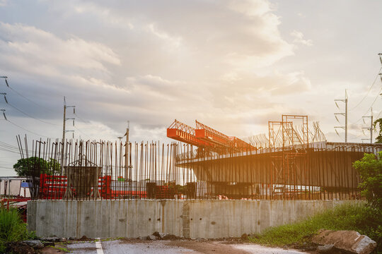 Backdrop of buildings at a construction site for new concrete roads and bridges represents urban development in transportation, a crucial infrastructure for a major city.