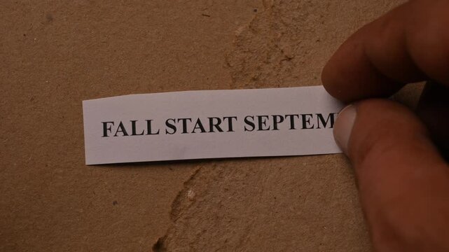 Fall Start September Text on Tiny Paper Placed on Black Book Background