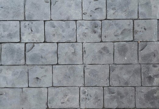 Grey stamped concrete pavement floor texture background, top view of stone tiles walkway texture.