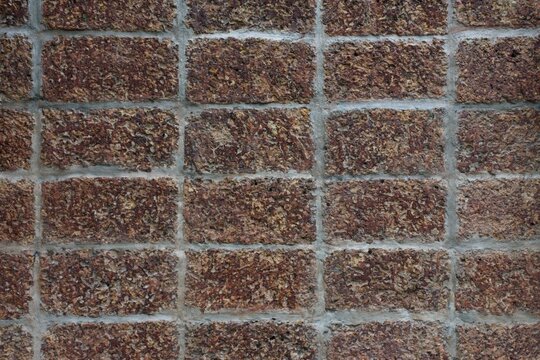 ​laterite wall, laterite stone, brick wall, porous texture, reddish brown, stone masonry, mortar joints, rough surface, construction material, architectural background, ancient wall, weathered stone, 