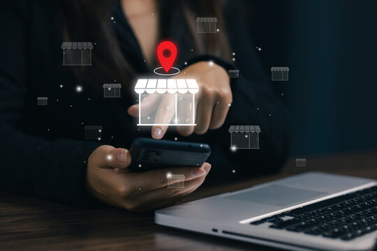 Businesswoman uses smartphone with virtual store and location icons, representing ecommerce, local business search, online shopping, retail technology, marketing, and mobile marketplace.