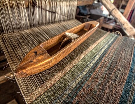 Vintage wooden shuttle on traditional weaving loom.