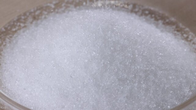 Macro View of White Granulated Sugar Pouring into a Pile
