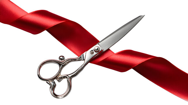 Scissors cutting through a red ribbon on a white background with pair silver scissors glossy red silk celebration ceremony symbolic isolated