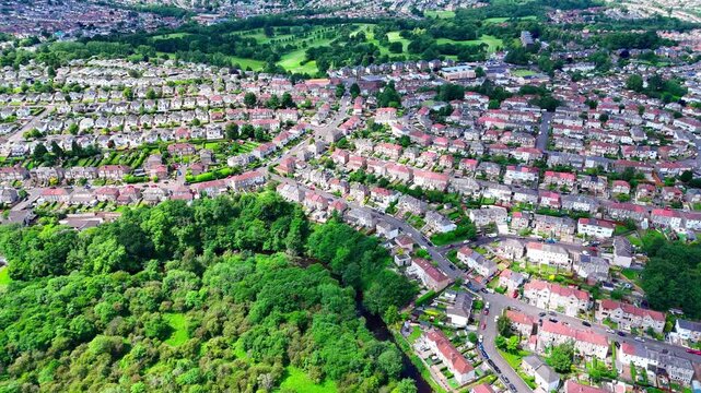 Stamperland, Glasgow, Scotland, showcasing a suburban residential neighbourhood with surrounding woodland, parkland and local streets captured from above