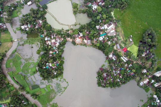 Aerial view of a densely populated rural settlement beside a murky river