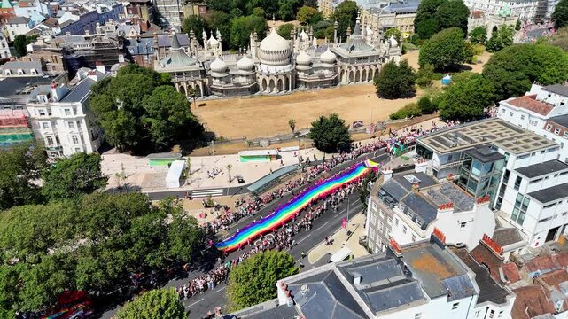 Aerial view of vibrant crowds and colourful floats during the Brighton and Hove Pride LGBTQ Community Parade.