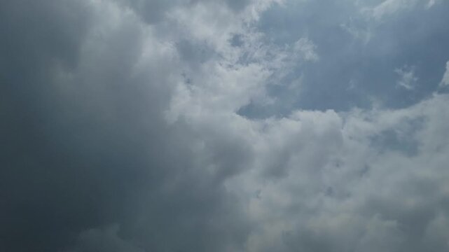 Dense gray storm clouds gathering in the sky during a cloudy summer day