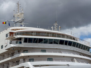 Antwerpen, Belgium, July 20, 2026 - Luxury cruise ship bridge and upper decks with Belgian flag against dramatic cloudy sky in Antwerpen, België © Bjorn B