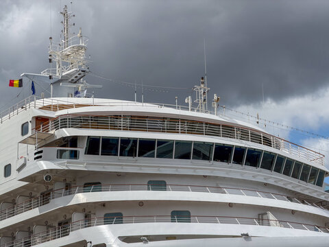 Antwerpen, Belgium, July 20, 2026 - Luxury cruise ship bridge and upper decks with Belgian flag against dramatic cloudy sky in Antwerpen, Belgi&euml;