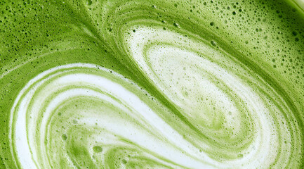 Obraz na płótnie Canvas a frothy matcha latte, known for its distinctive emerald hue and subtle swirls of creamy foam, captured in both macro and wide-angle shots, featuring a detailed texture close-up and viewed from the to